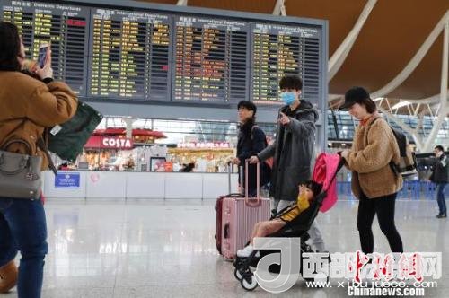 旅客帶著孩子前往辦票柜臺辦理登機(jī)手續(xù)?！∫罅⑶?攝