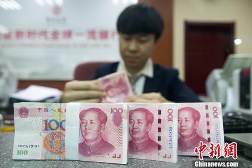 11月5日，人民幣中間價(jià)漲勢(shì)延續(xù)。中國外匯交易中心報(bào)人民幣對(duì)美元匯率中間價(jià)為6.8976，較前一交易日大幅上調(diào)395個(gè)基點(diǎn)，重新返回6.8區(qū)間，創(chuàng)下近一個(gè)月以來的最高值。圖為11月1日，山西太原一銀行工作人員正在清點(diǎn)貨幣。<a target='_blank'  data-cke-saved- ><p  align=