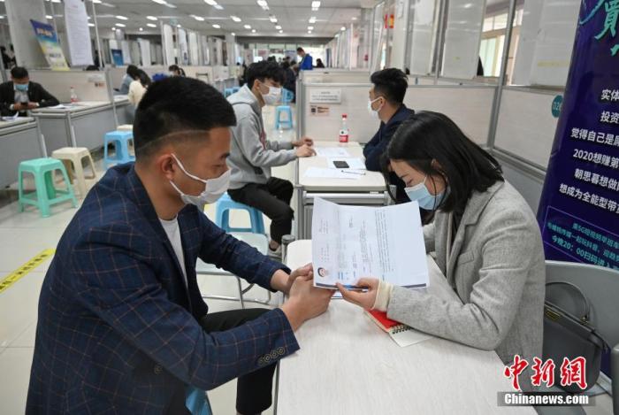 4月14日，招聘者在查看求職者簡歷。<a target='_blank'  data-cke-saved- >中新社</a>記者 王剛 攝