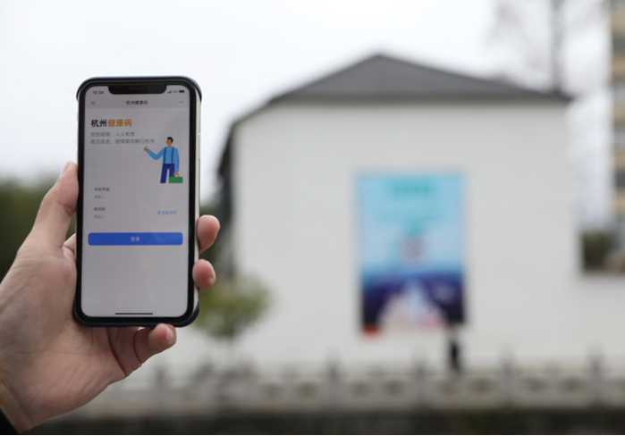 在浙江省杭州市臨安區(qū)天目山鎮(zhèn)，一名居民在“杭州健康碼”海報上掃碼申領個人二維碼。新華社發(fā)