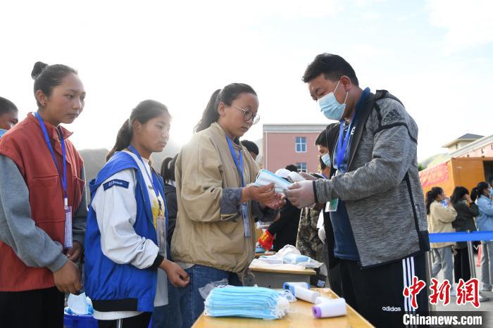 7月7日，考生在拉薩三高考點(diǎn)外領(lǐng)取口罩?！『闻罾?攝