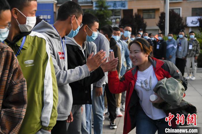 7月7日，拉薩三高考點(diǎn)外，領(lǐng)隊(duì)老師與考生擊掌鼓勁加油?！『闻罾?攝